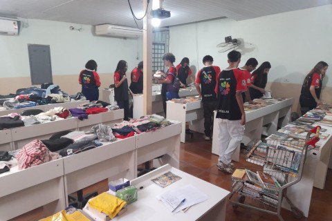 Atendidos recebendo doações de diversos livros e roupas